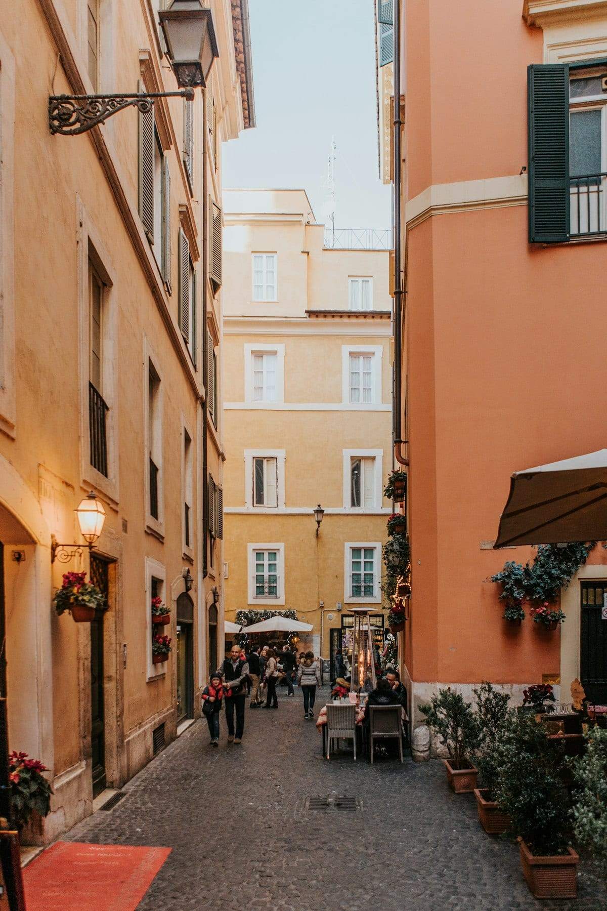 A quiet, narrow street between tall orange and yellow buildings