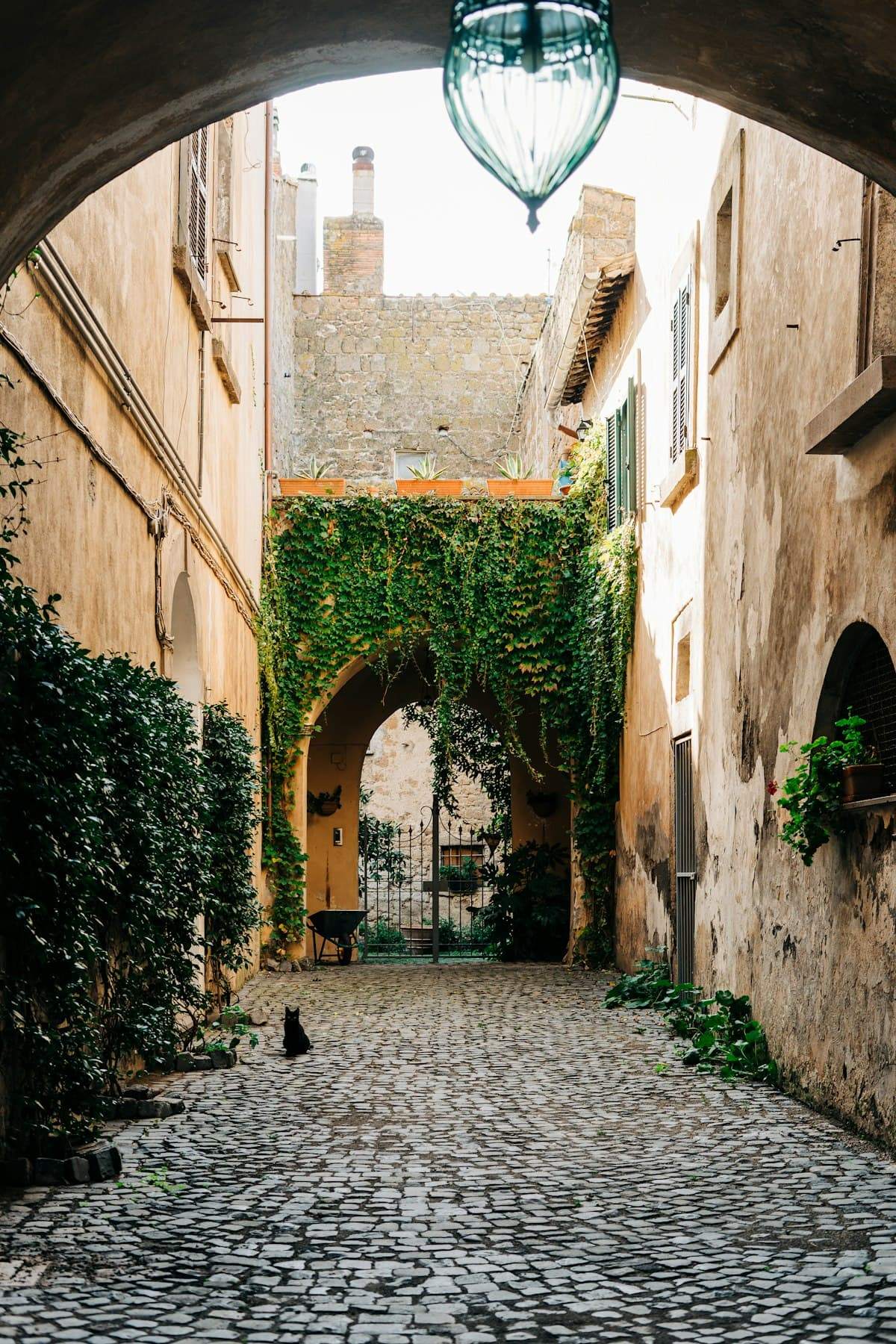 An ivy-covered archway into a quiet courtyard